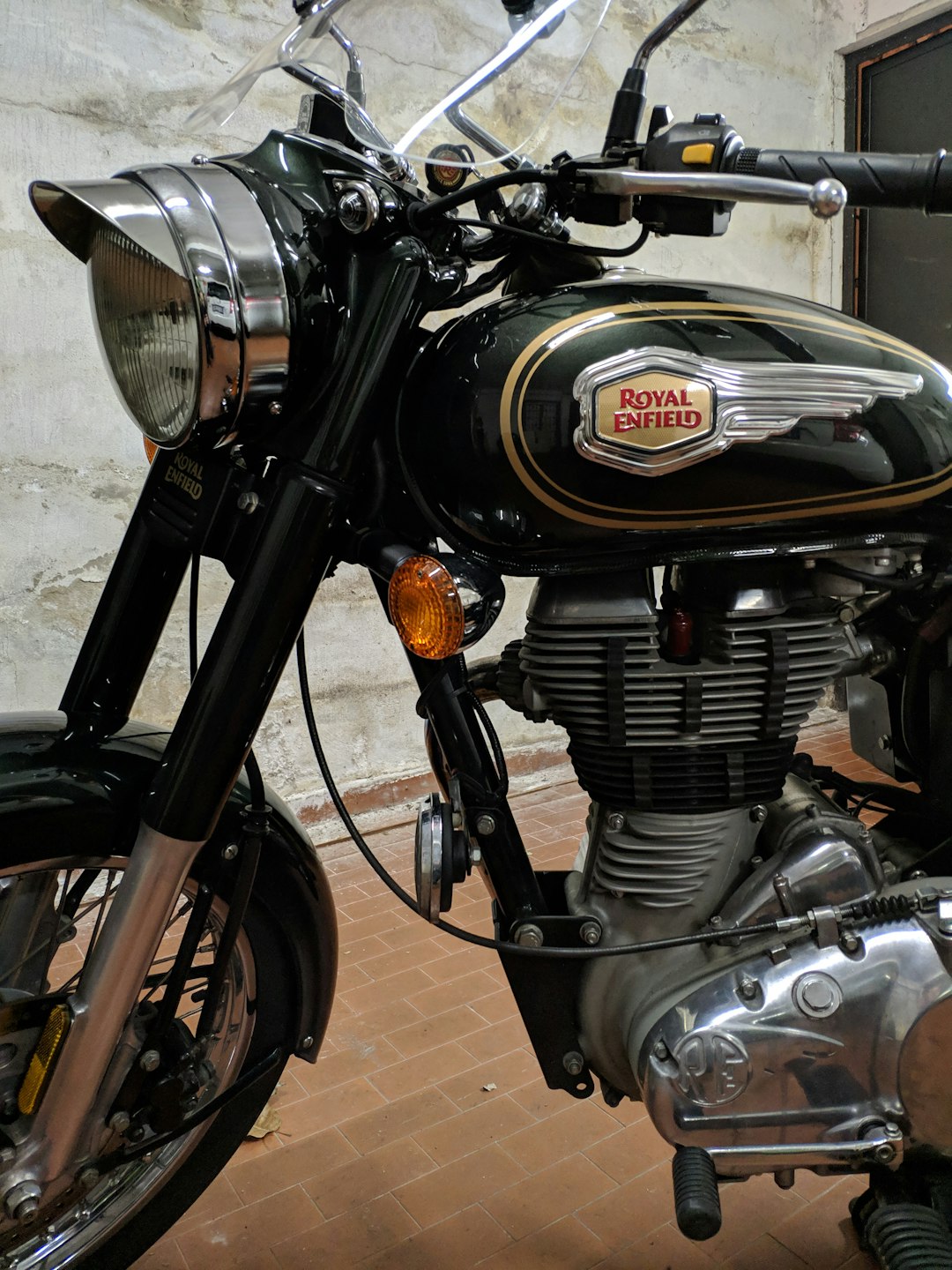 a-black-and-gold-motorcycle-parked-in-front-of-a-building-gcnb1yi7dk8